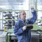 Operator with bobbin of carbon fibre in carbon fibre production facility